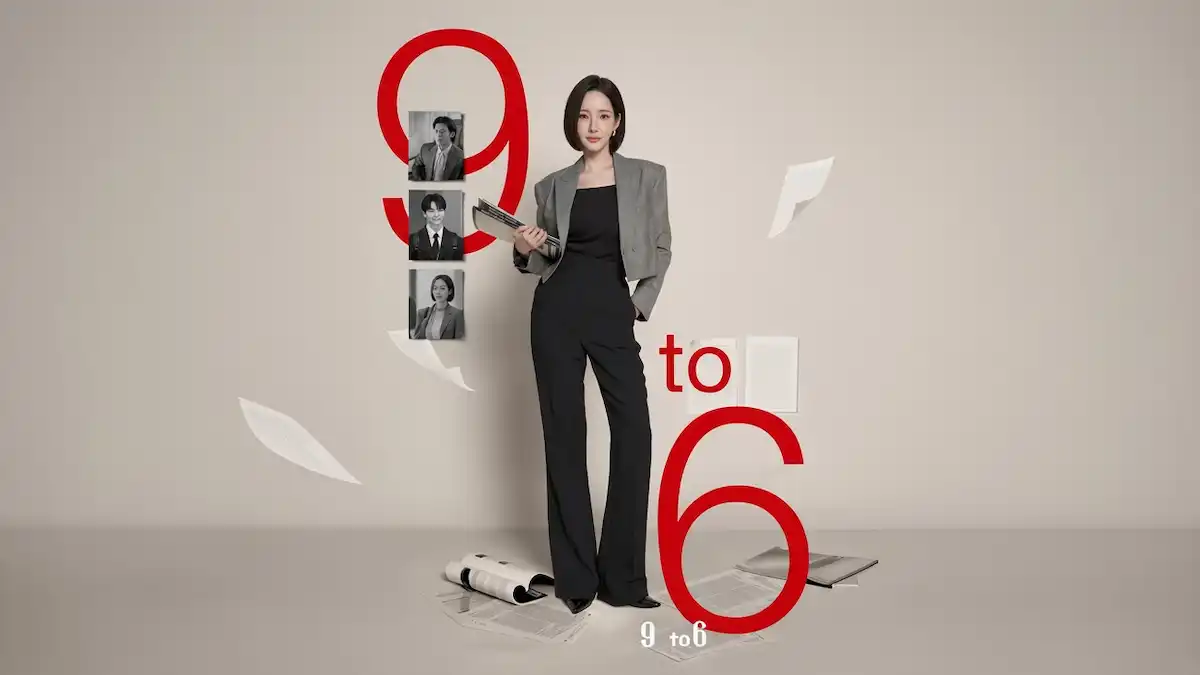 A short-haired woman in a grey blazer and black jumpsuit standing amidst giant red numbers spelling 9 to 6 with scattered papers.